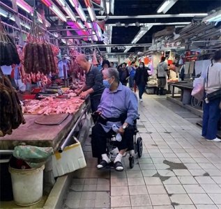 ​洪金宝独自坐轮椅买菜，在档口挑猪肉，穿凉鞋白发苍苍似普通大爷